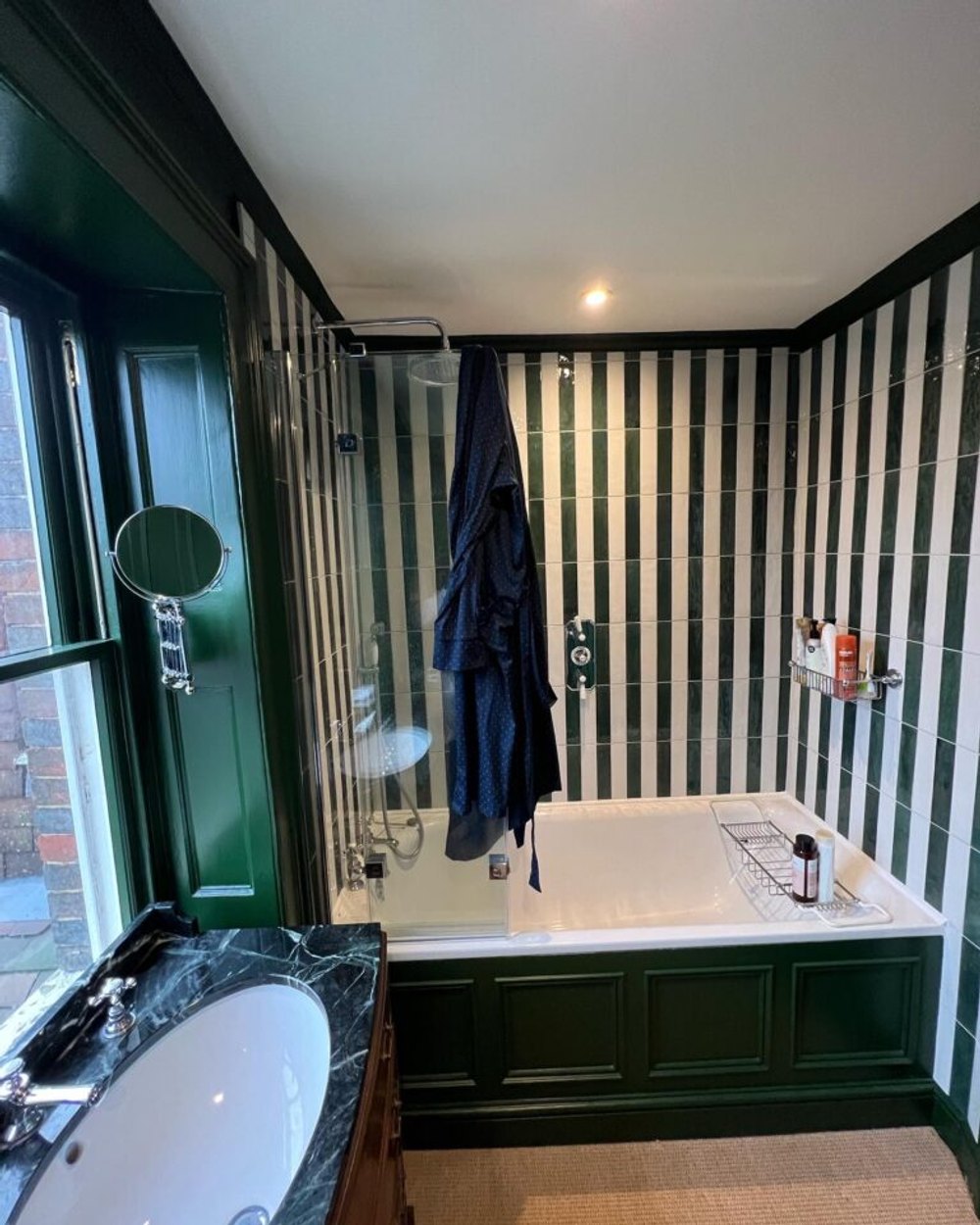 Bathroom decorated with green panelling and striped walls