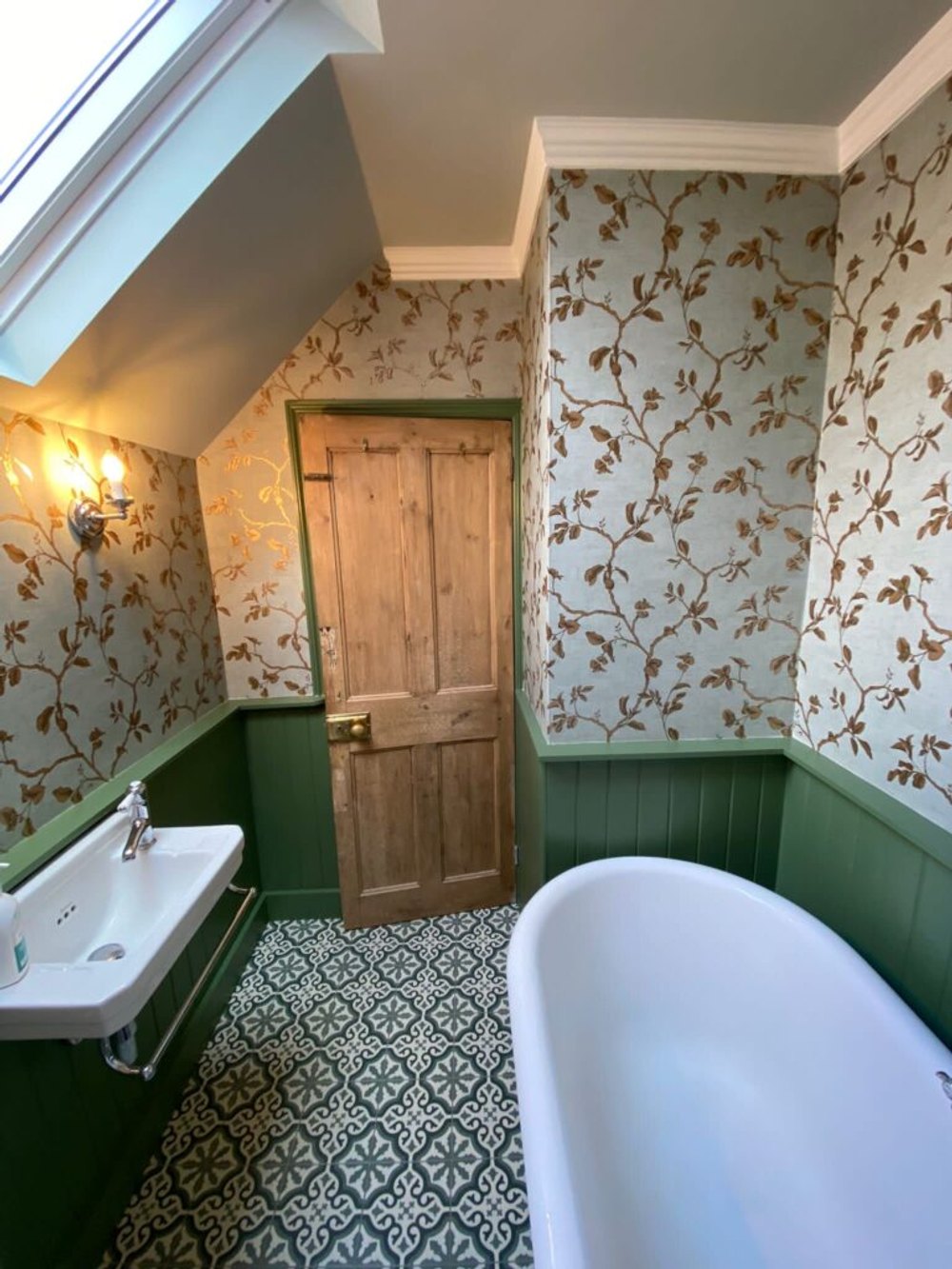 Bathroom with floral wallpaper and green painted panelling